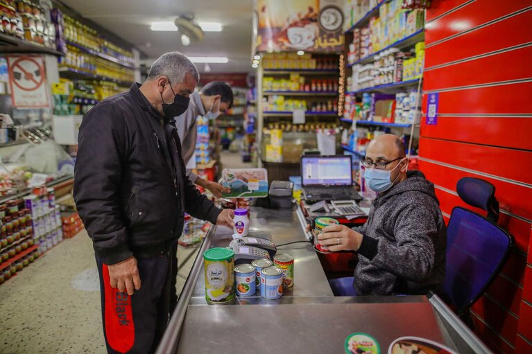 محمد وهو يختار الأطعمة ومستلزمات المعيشة لأسرته باستخدام قسيمة إلكترونية. تصوير محمد ريفي لصالح منظمة خدمات الإغاثة الكاثوليكية