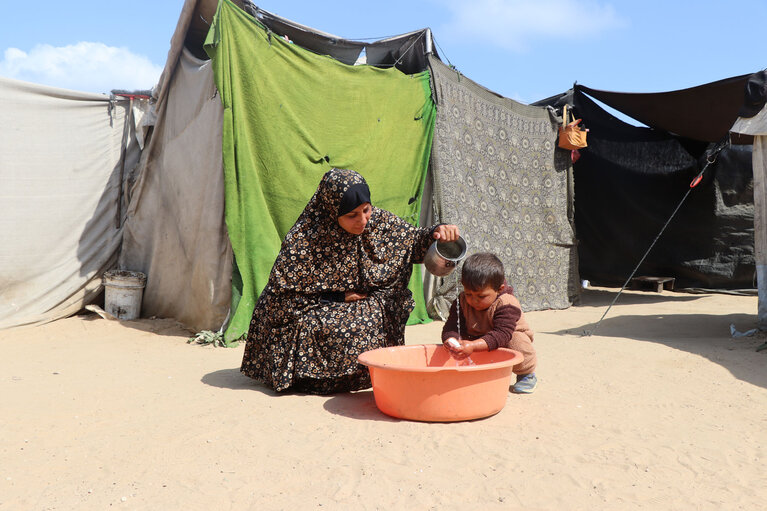 Suad* giving clean water to her three-year-old son Rasheed*