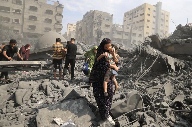 Palestinians in Gaza city inspect the damage following an Israeli airstrike, 9 October 2023, photo by Mahmud HAMS / AFP