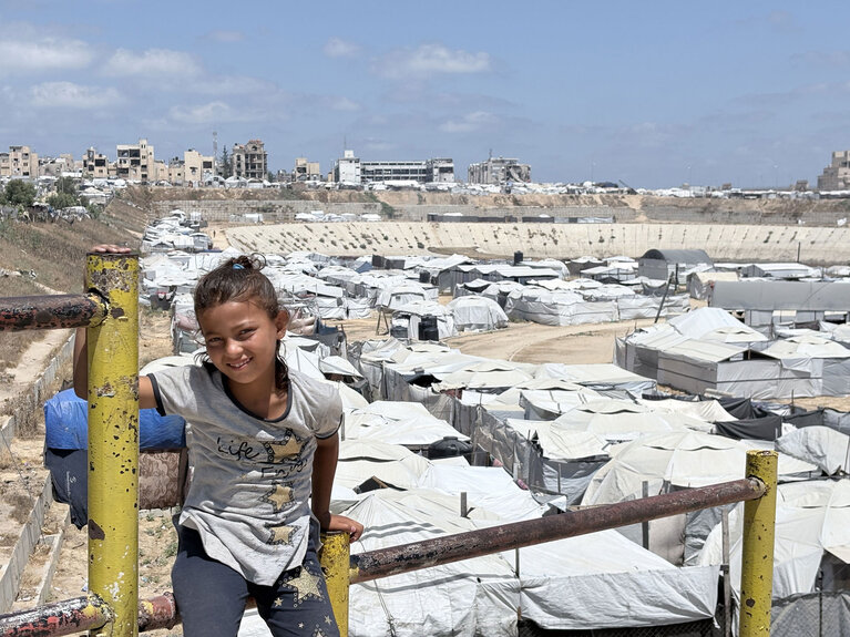 A child stands near a displacement site in Gaza, where WASH activities helped reduce environmental health risks for displaced families. Photo credit: PEF
