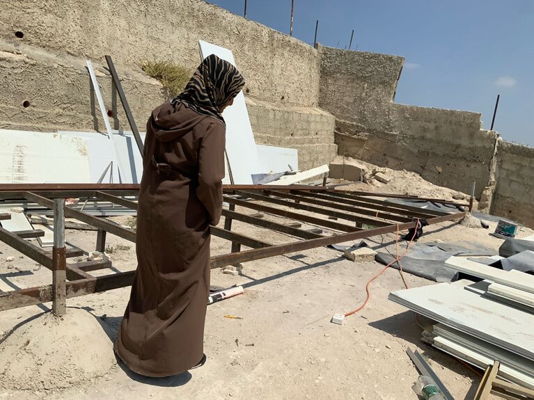 A Palestinian woman in front of her demolished home in Jabal al Mukabbir area of East Jerusalem. Photo by OCHA