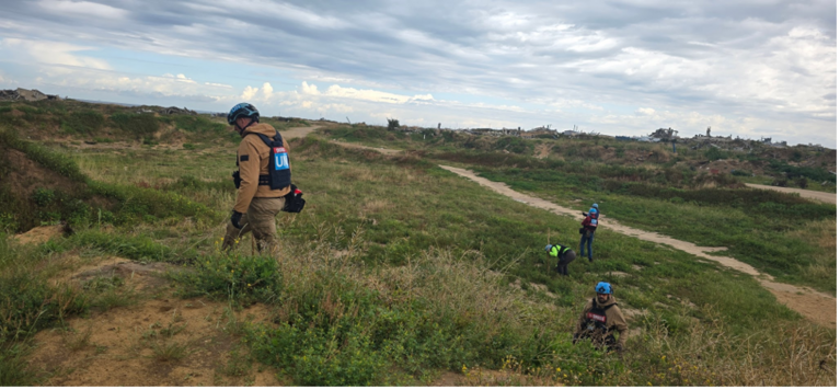 Explosive ordnance disposal officers inspecting an agricultural field in Sheikh Ajleen area for potential hazards. Photo by UNMAS