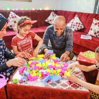 Asma and Sade playing with two of their daughters in their renovated livingroom.