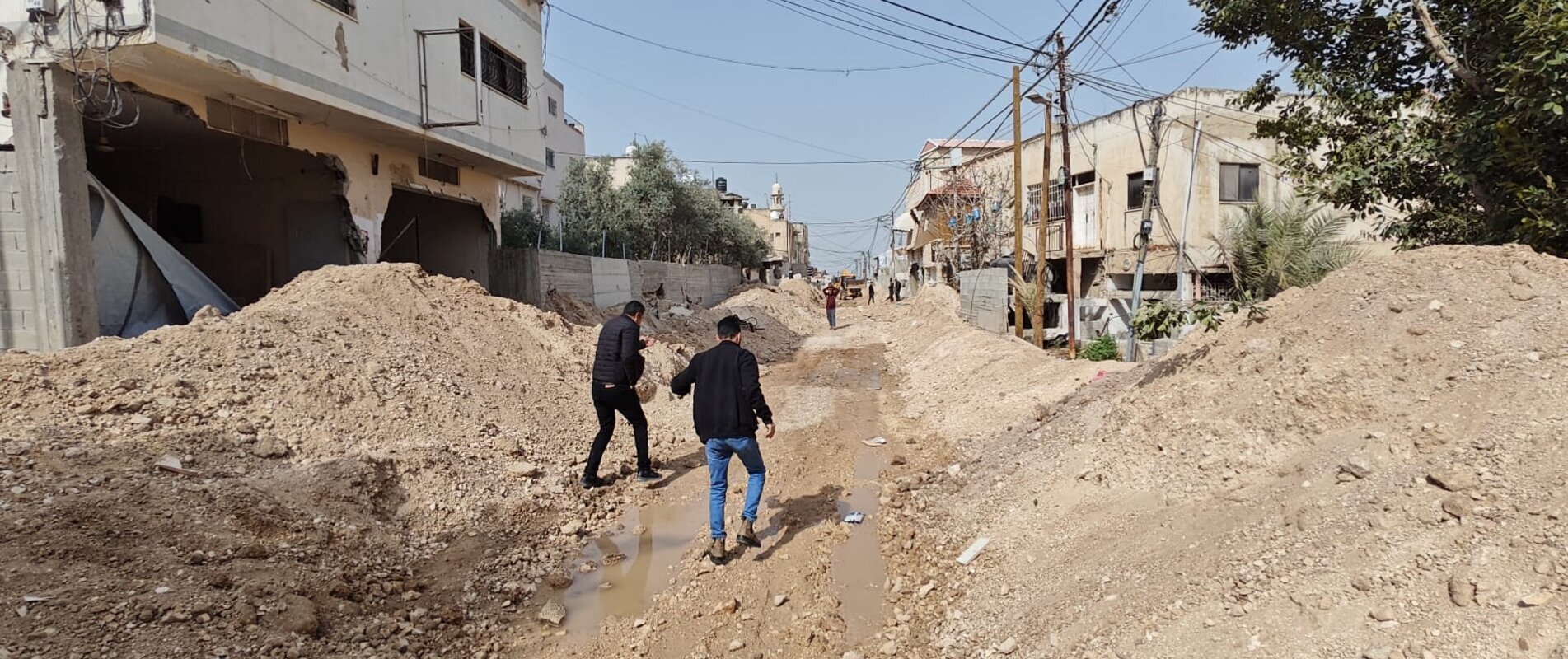 People walking through an area of Jenin city, near Jenin Camp, destroyed by Israeli forces. Photo courtesy of the Jenin Municipality. 