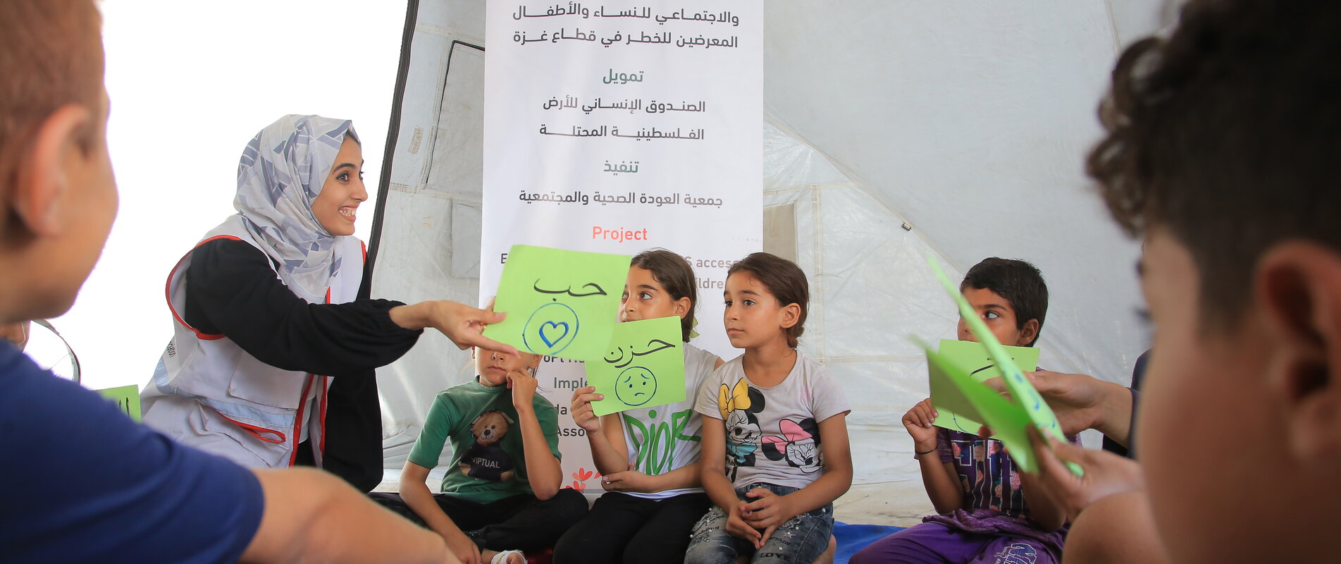 AWDA team member providing psychosocial support to children in Gaza, 2023. Photo by AWDA. (Sara and her children are not pictured.)