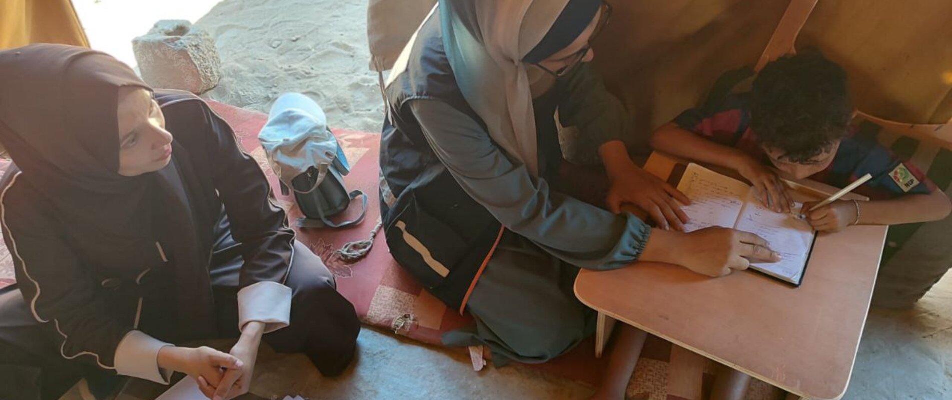 Eight-year-old Ibrahim while using his customized slant board to study, September 2025. Photo by EducAid