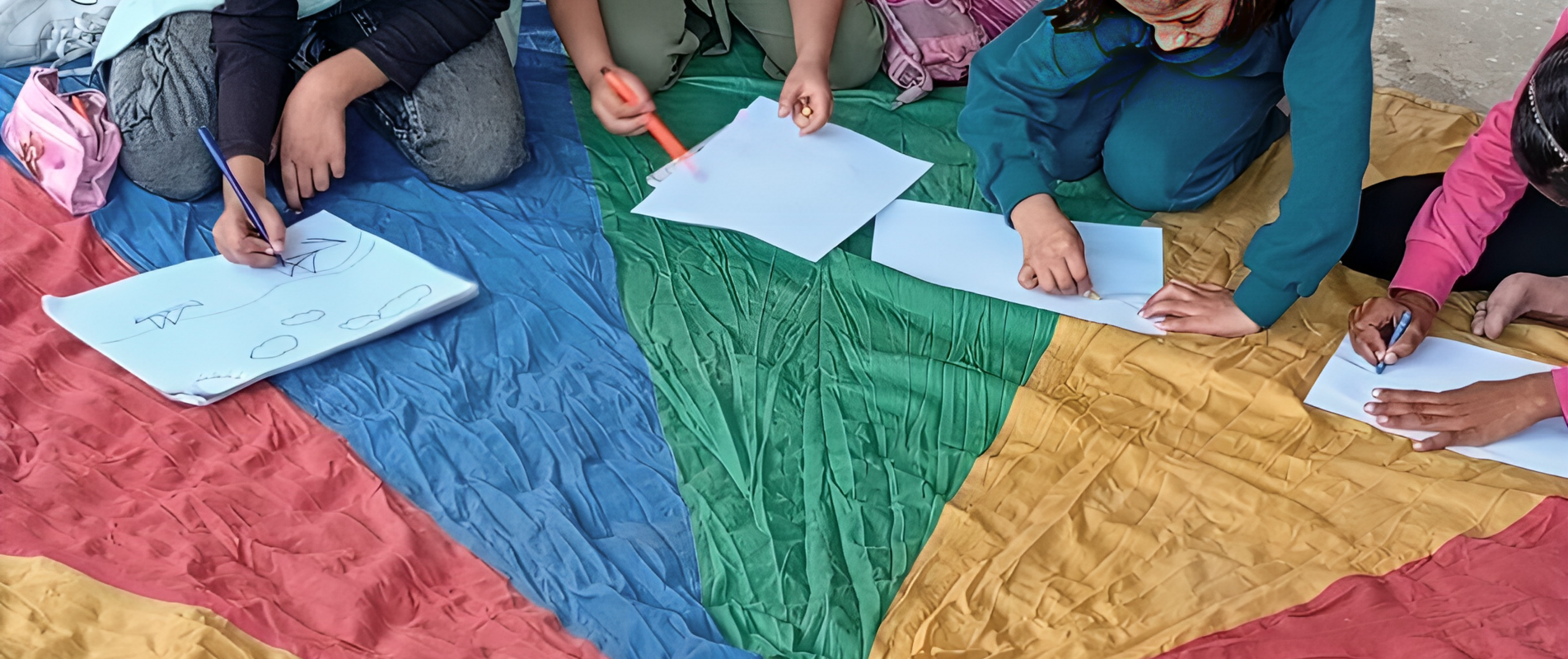 Tala and other children drawing in a temporary learning space in 2025. Photo by NRC. 