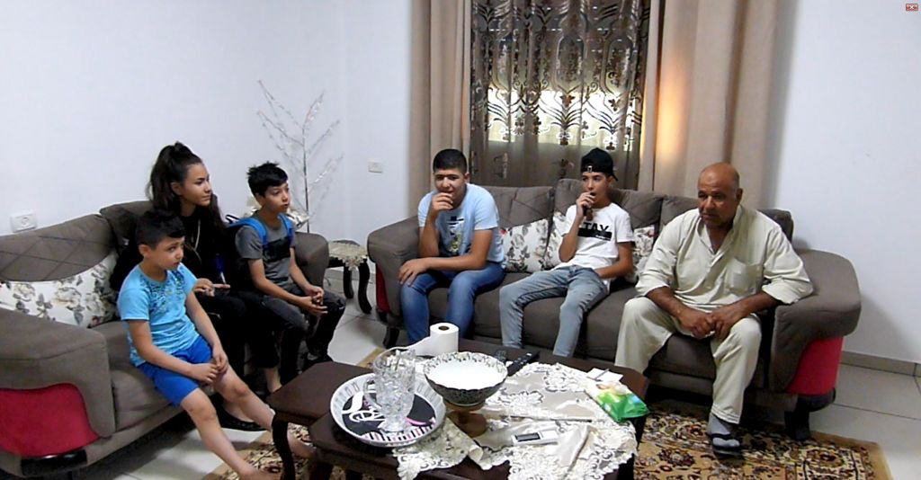 Ghaleb Abu Hadwan, a 63-year-old Palestinian from Sur Bahir, sitting in his living room with family members a few days before the demolition, July 2019. Photo by OCHA