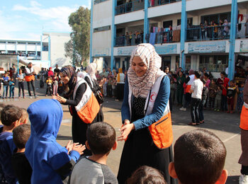 متطوعون يقدمون الدعم النفسي الاجتماعي للأطفال في جنوب غزة من خلال الأنشطة الترويحية في مدرسة تُستخدم كمأوى للمُهجّرين. تصوير جمعية الهلال الأحمر الفلسطيني